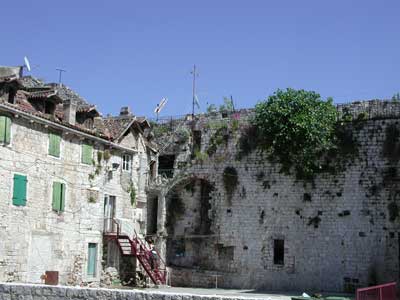 Les maisons médiévales et les figuiers ont colonisé les remparts du palais antique